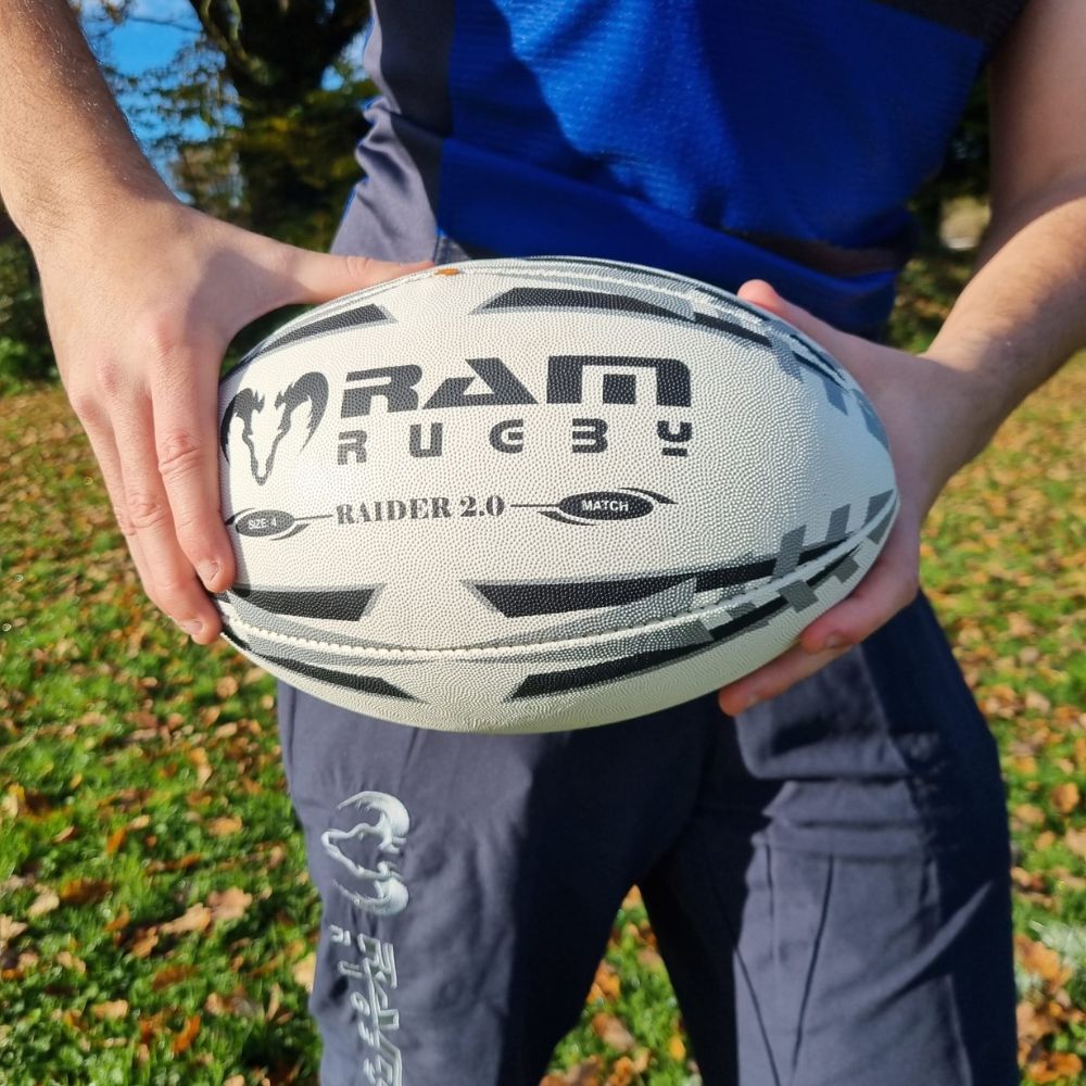 Close-up of Ram Rugby Raider 2.0 durable match ball showing textured rubber laminate and valve-in-seam design for play
