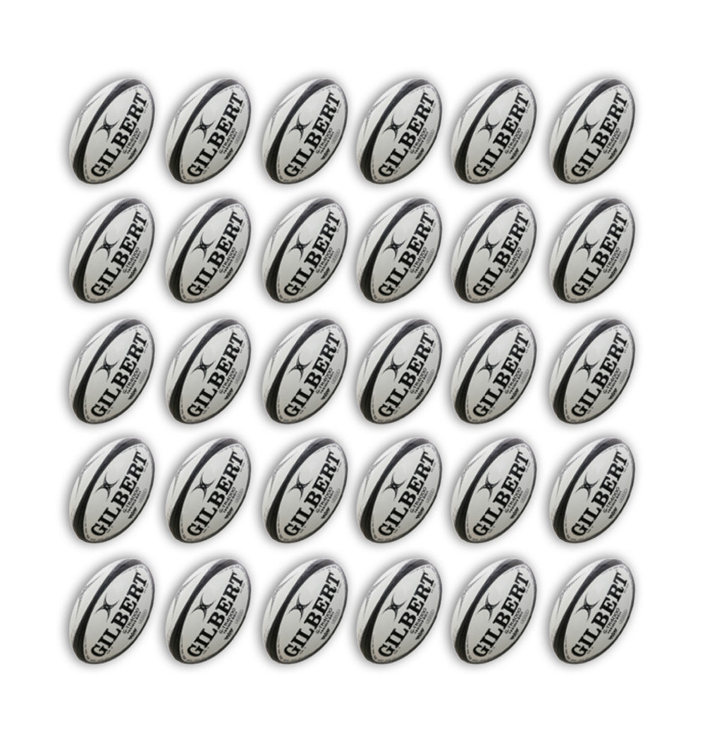 Gilbert G-TR4000 trainer rugby balls in vibrant white and green, stacked neatly with two large breathable ball bags included