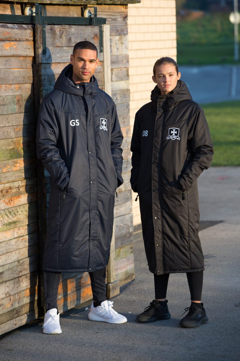 Ram Rugby Custom Stock Bench Coat in black waterproof thermal fabric with zipped side pockets for warmth and secure storage